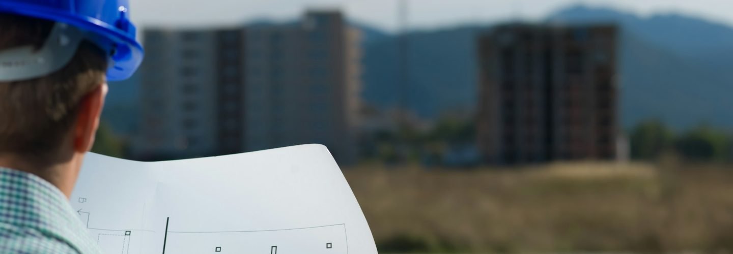 architect reading technical drawing of construction